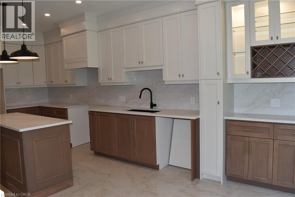Kitchen featuring a central island with quartz top and backsplash, two-tone cabinetry, recessed lighting - 8 Dunlop Road, Hamilton, ON - Indoor Photo Showing Kitchen