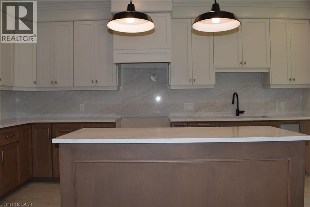 Modern kitchen featuring a two-tone cabinetry design with crisp white upper cabinets and rich wood-finish lower cabinetry - 8 Dunlop Road, Hamilton, ON - Indoor Photo Showing Kitchen