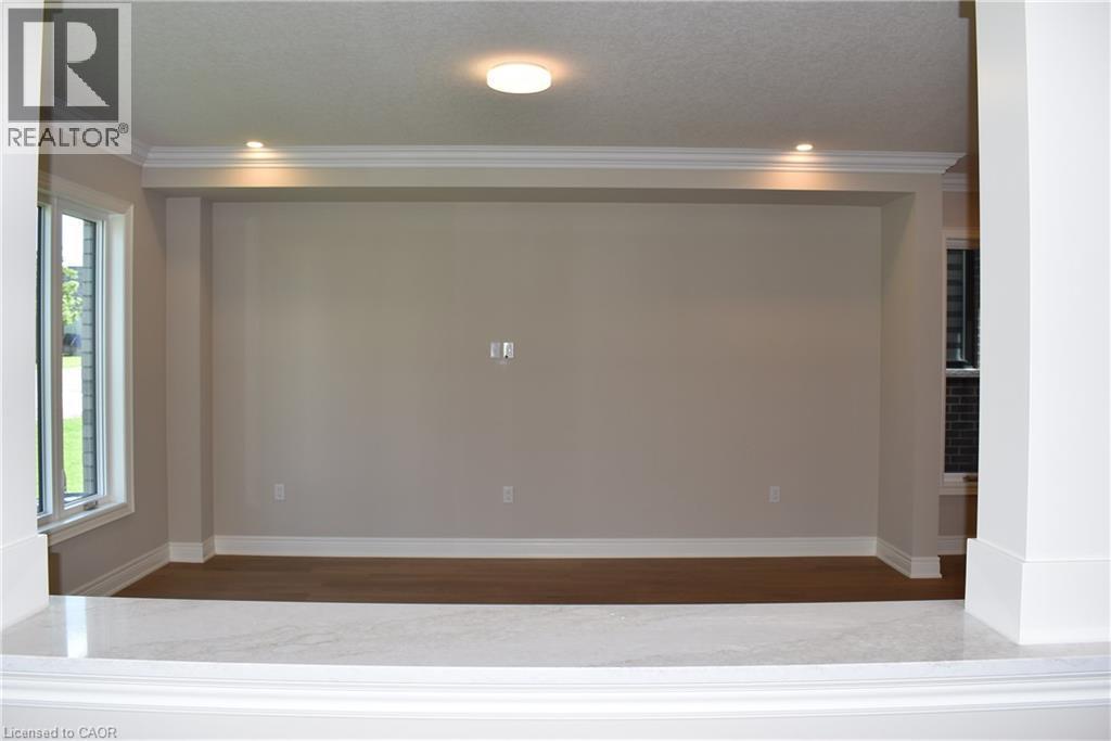 Spacious room featuring recessed ceiling lighting, neutral wall finishes, wood-finish flooring, and large window with natural light - 8 Dunlop Road, Hamilton, ON - Indoor Photo Showing Other Room