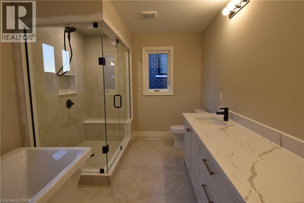Spa-inspired primary bathroom featuring a frameless glass-enclosed shower with marble-look surround, freestanding soaking tub, dual-sink vanity with quartz countertop and matte black hardware, heated - 8 Dunlop Road, Hamilton, ON - Indoor Photo Showing Bathroom