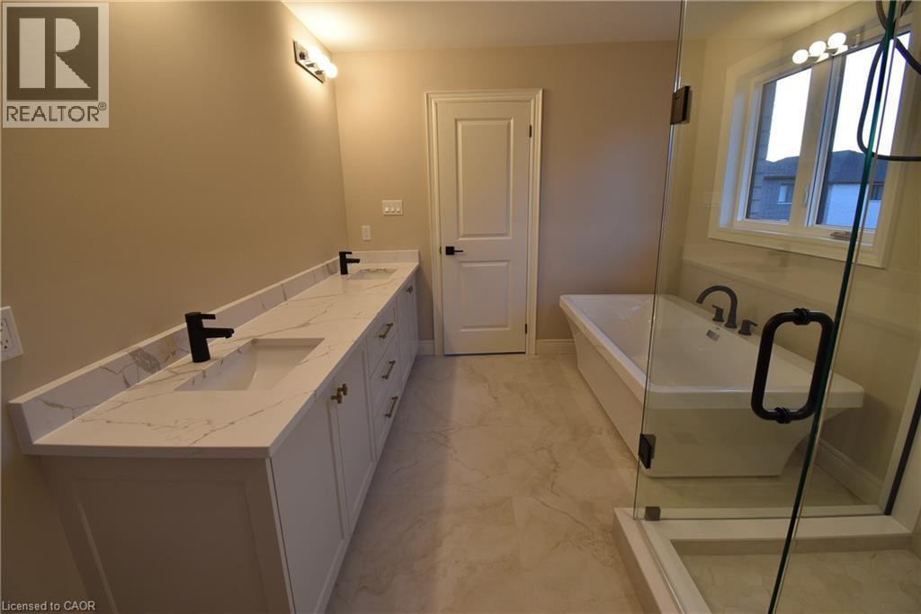 Spa-inspired primary bathroom featuring dual vanities with white cabinetry, quartz countertops, and matte black faucetry - 8 Dunlop Road, Hamilton, ON - Indoor Photo Showing Bathroom