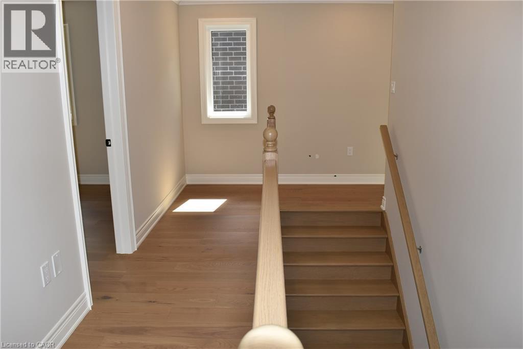 Elegant staircase with natural wood-finish treads and a coordinating handrail, bathed in natural light from an upper window - 8 Dunlop Road, Hamilton, ON - Indoor Photo Showing Other Room