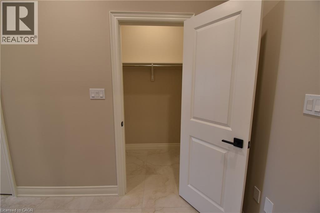 Spacious walk-in closet featuring built-in shelving, a hanging rod for full-length garments, and neutral finishes throughout - 8 Dunlop Road, Hamilton, ON - Indoor Photo Showing Other Room