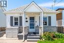 Gabled roofline with white siding and gray stone veneer detailing - 71 Beland Avenue N, Hamilton, ON 
