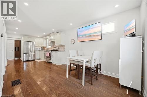Kitchen area featuring wood-finish flooring, white cabinetry, stainless steel appliances, and recessed lighting - 71 Beland Avenue N, Hamilton, ON 