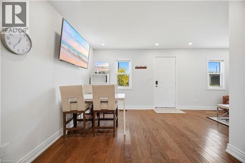 Open-concept living area with wood-finish flooring, white walls, and recessed lighting - 71 Beland Avenue N, Hamilton, ON 