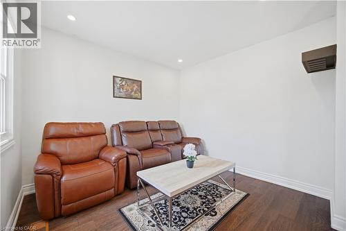 Bright room featuring dark wood-finish flooring, white baseboards, and recessed lighting - 71 Beland Avenue N, Hamilton, ON 