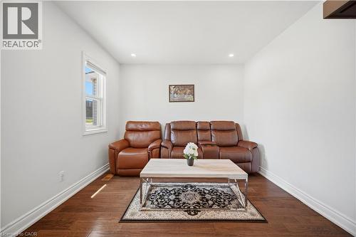 Bright interior space featuring a window, recessed lighting, and rich wood-finish flooring - 71 Beland Avenue N, Hamilton, ON 