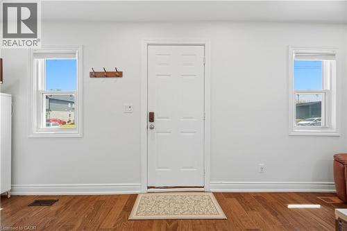 Entryway with a paneled white door, wood-finish flooring, and two double-hung windows - 71 Beland Avenue N, Hamilton, ON 