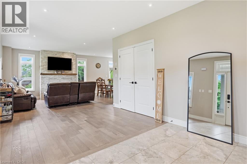 Open-concept living area with wood-finish flooring, recessed lighting, and light-toned wall paint - 1 Lindsay Way, Grimsby, ON - Indoor Photo Showing Other Room With Fireplace