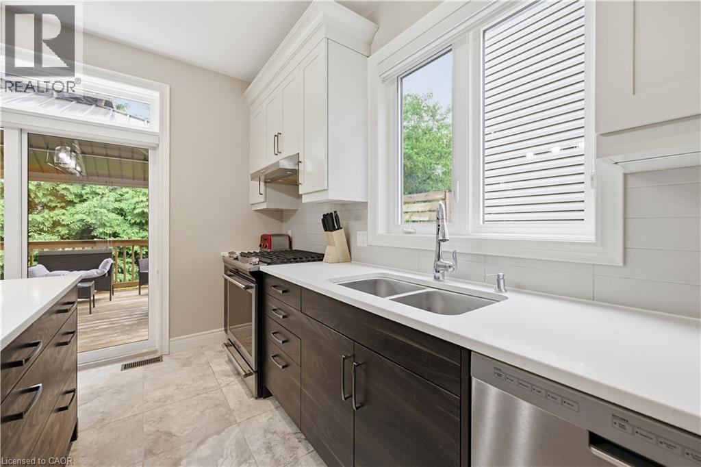 Contemporary kitchen featuring two-tone cabinetry, stainless steel appliances, a double basin sink, and white countertops - 1 Lindsay Way, Grimsby, ON - Indoor Photo Showing Kitchen With Double Sink