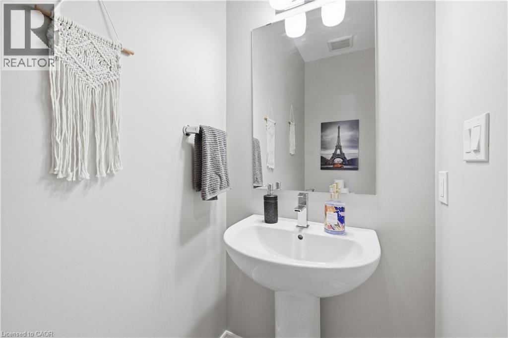 Pedestal sink with chrome faucet, large vanity mirror, and overhead light fixture - 1 Lindsay Way, Grimsby, ON - Indoor Photo Showing Bathroom