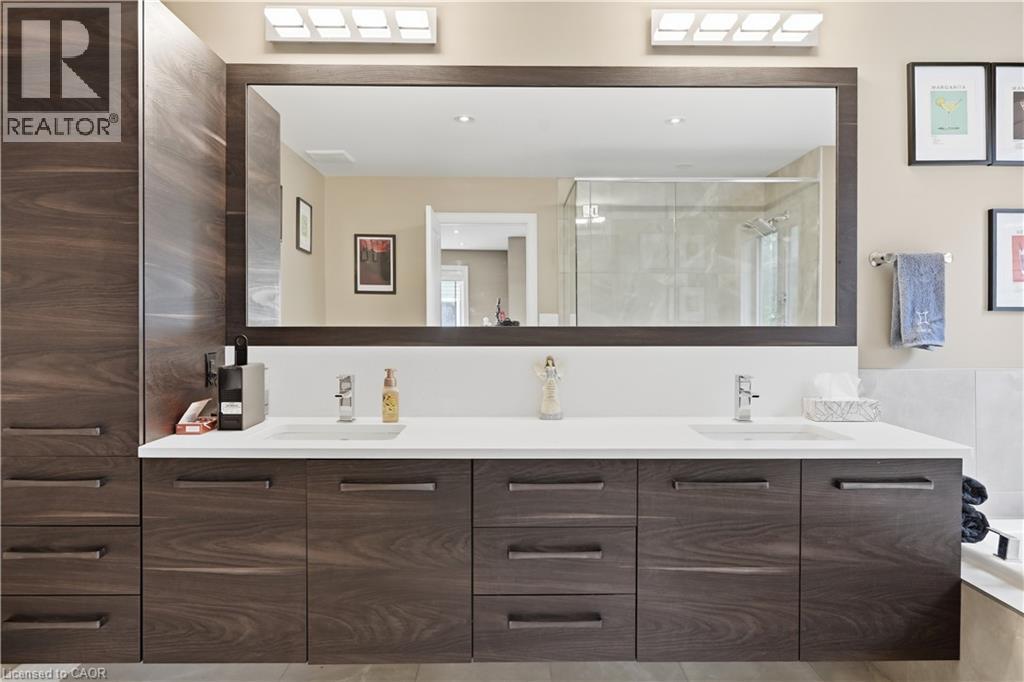 Bathroom vanity featuring dual under-mount sinks, a white countertop, and wood-finish cabinetry - 1 Lindsay Way, Grimsby, ON - Indoor Photo Showing Bathroom