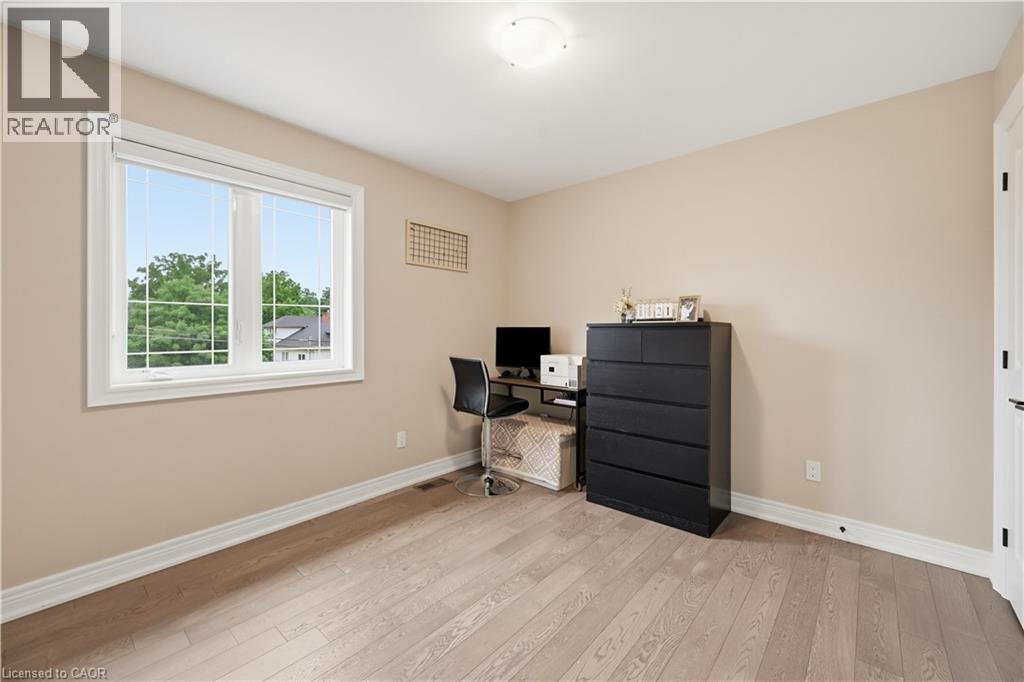 Spacious room featuring light wood-finish flooring, neutral wall paint, and white baseboards - 1 Lindsay Way, Grimsby, ON - Indoor Photo Showing Other Room