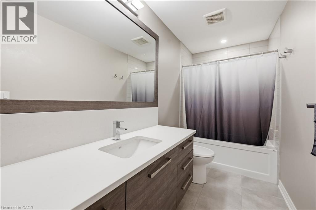 Bathroom featuring a contemporary vanity with a white countertop, undermount sink, and chrome faucet - 1 Lindsay Way, Grimsby, ON - Indoor Photo Showing Bathroom