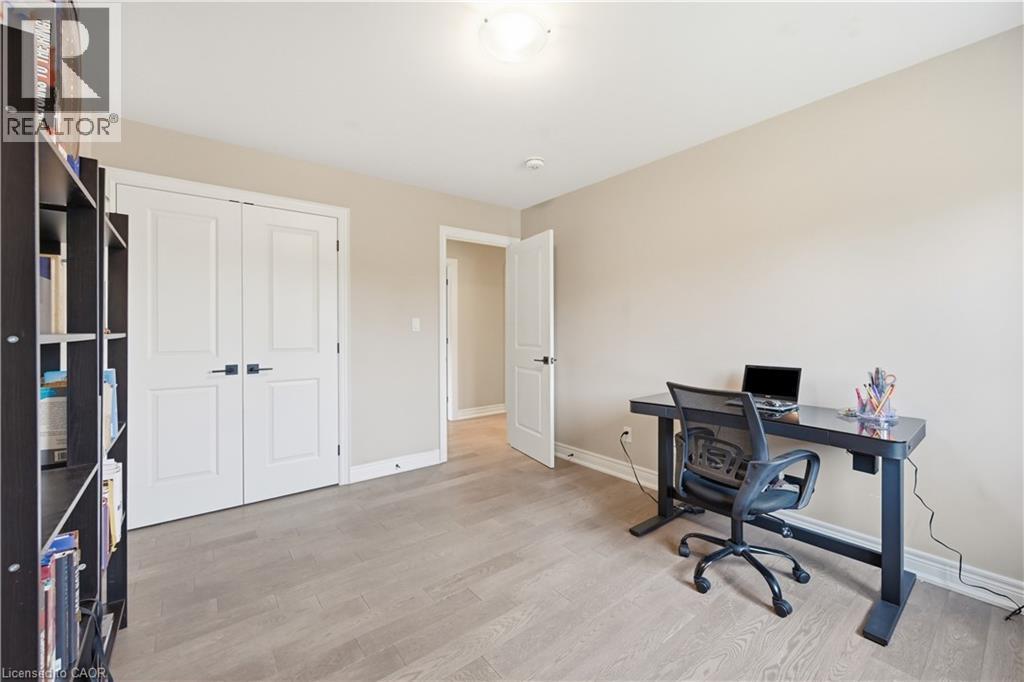 Neutral wall tones, wood-finish flooring, white trim, and a double-door closet with black hardware - 1 Lindsay Way, Grimsby, ON - Indoor Photo Showing Office