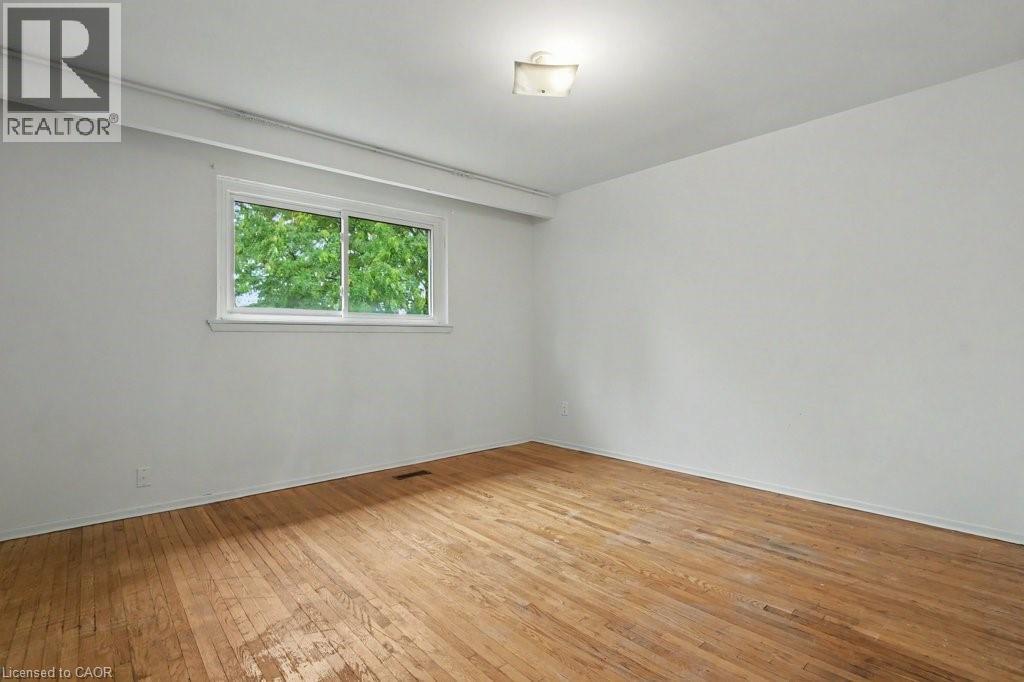 Light-filled interior space featuring wood-finish flooring, white walls, and a white framed window - 396 Pinemeadow Avenue, Mississauga, ON