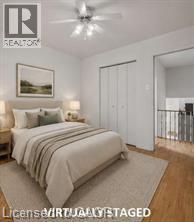 Bedroom featuring wood-finish flooring, a ceiling fan with integrated lighting, and white bi-fold closet doors - 396 Pinemeadow Avenue, Mississauga, ON