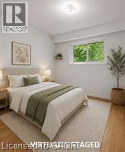 Light-filled room featuring wood-finish flooring, a flush-mount ceiling light, and a window with exterior foliage - 396 Pinemeadow Avenue, Mississauga, ON