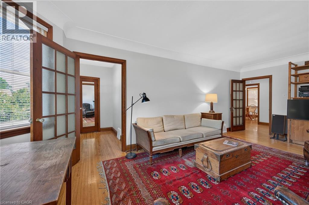 Living area featuring light hardwood flooring, light gray wall paint, and crown molding - 83 Aberfoyle Avenue, Hamilton, ON
