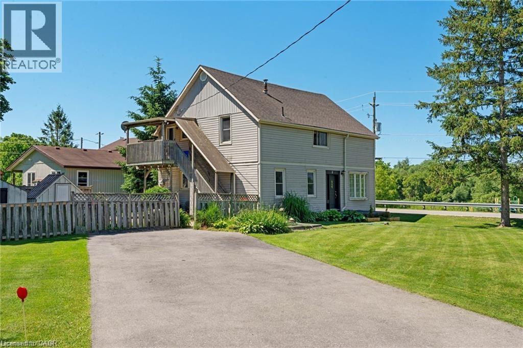 Two-story residential structure with light-colored siding, a dark roof, and multiple windows - 2 Mill Street E, York, ON