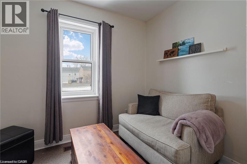 Bright room featuring a large double-hung window with white trim, light-colored walls, and a built-in wall shelf - 2 Mill Street E, York, ON