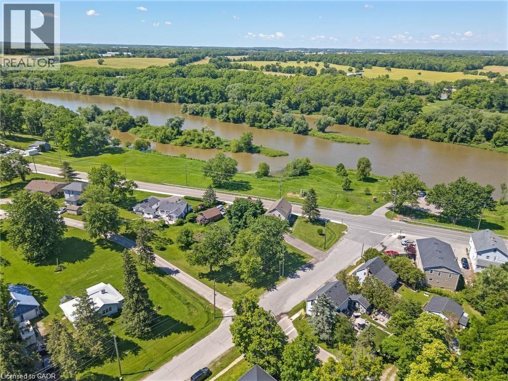 Aerial perspective showcasing a riverside community with residential properties and abundant green spaces - 2 Mill Street E, York, ON