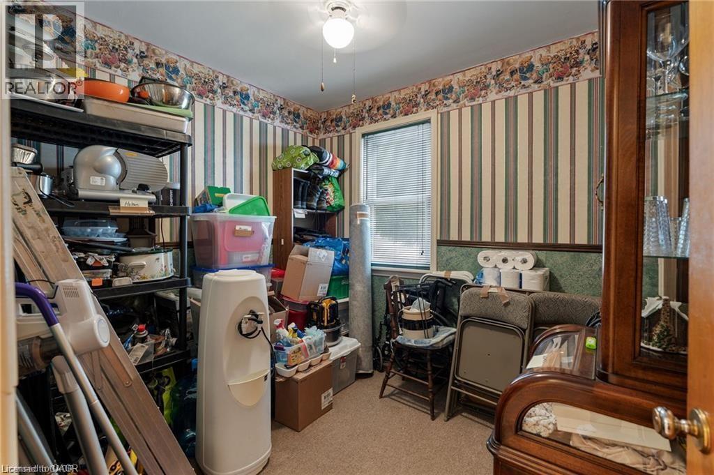 Carpeted room with a ceiling light fixture, window with blinds, and striped wallpaper with a decorative border - 2 Mill Street E, York, ON