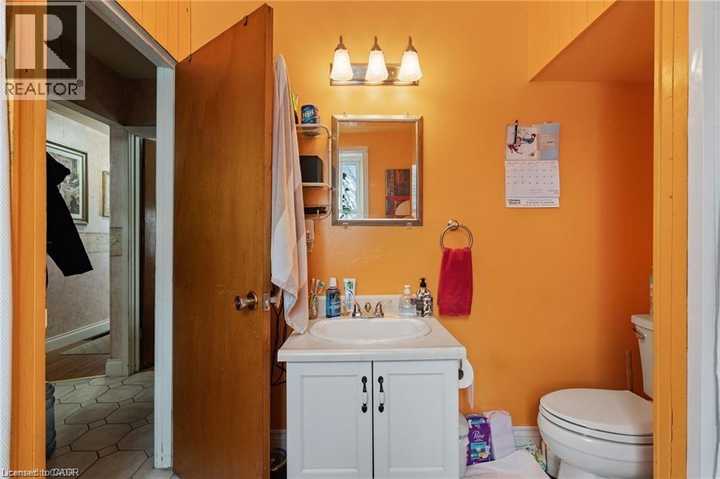 Bathroom featuring a vanity with white cabinetry, a single sink, and a wall-mounted mirror - 2 Mill Street E, York, ON