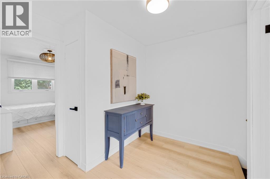 Hallway featuring wood-finish flooring, white walls, and a recessed ceiling light - 5275 Banting Court, Burlington, ON