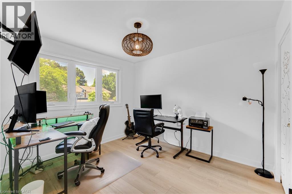 Bright room featuring wood-finish flooring, white walls, and a multi-pane window - 5275 Banting Court, Burlington, ON