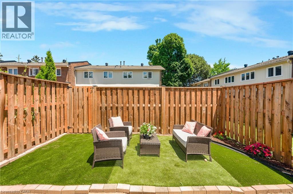 Enclosed backyard featuring a new wood fence and artificial turf - 5275 Banting Court, Burlington, ON