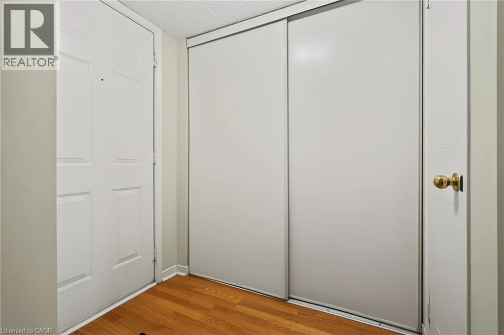 Hardwood-finish flooring, white paneled door, brass hardware, and sliding closet doors - 117 E Bristol Road E Unit# 64, Mississauga, ON