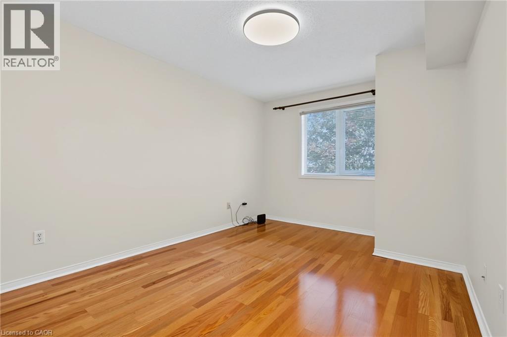 Bright room featuring wood-finish flooring, neutral wall paint, a single window, white baseboards, and a flush-mount ceiling light - 117 E Bristol Road E Unit# 64, Mississauga, ON