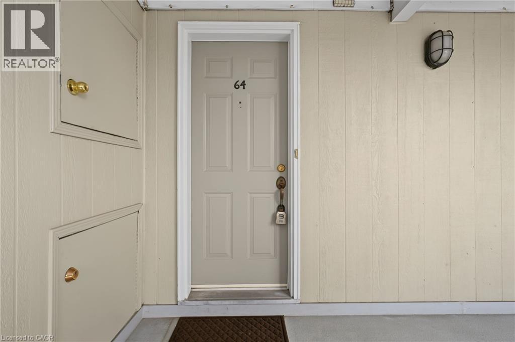 Entry door with panel detailing, brass hardware, and numerical address - 117 E Bristol Road E Unit# 64, Mississauga, ON