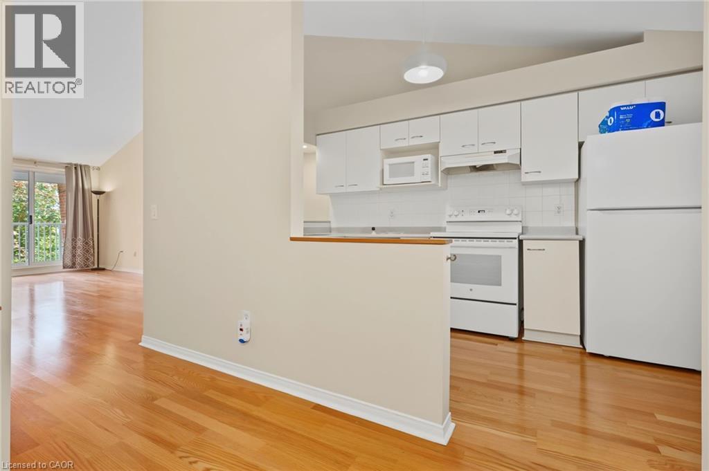 Kitchen featuring white cabinetry, white appliances, and a tile backsplash - 117 E Bristol Road E Unit# 64, Mississauga, ON