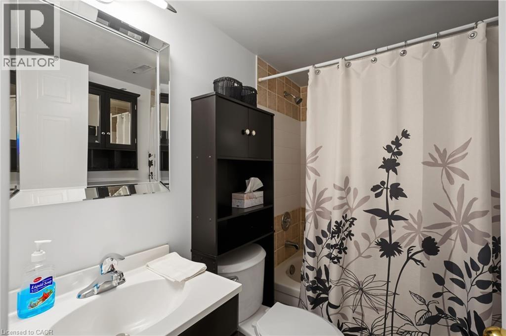 Bathroom featuring a white vanity with an integrated sink, polished chrome faucet, and a wall-mounted rectangular mirror - 117 E Bristol Road E Unit# 64, Mississauga, ON