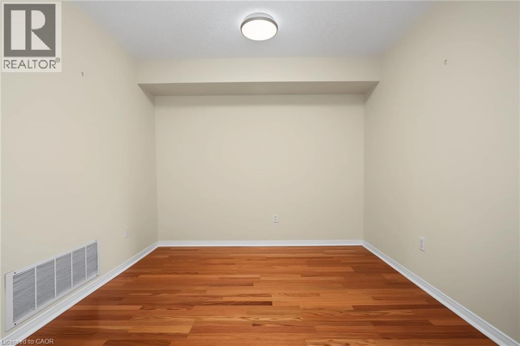 Room featuring wood-finish flooring, light neutral wall paint, and white baseboards - 117 E Bristol Road E Unit# 64, Mississauga, ON