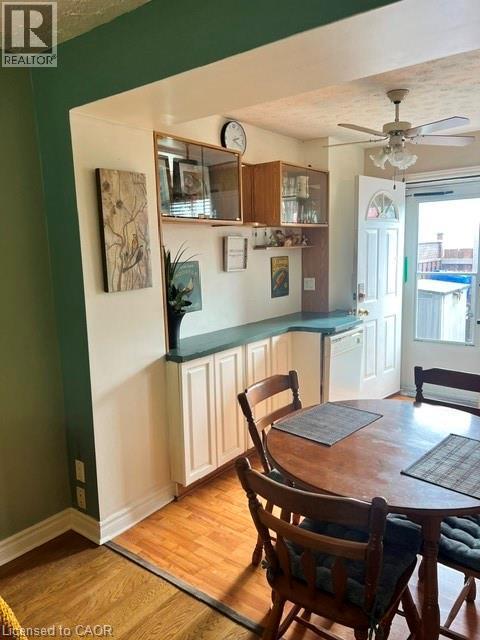 Dining area featuring wood-finish flooring, built-in lower cabinetry with dark countertops, and a ceiling fan - 227 Fergus Avenue, Kitchener, ON
