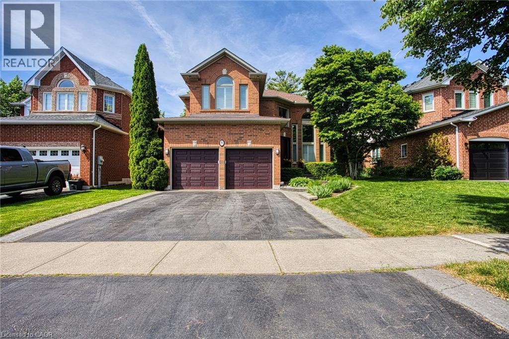 Brick facade residence featuring a double-door garage and a paved driveway - 5 Shetland Drive, Waterdown, ON