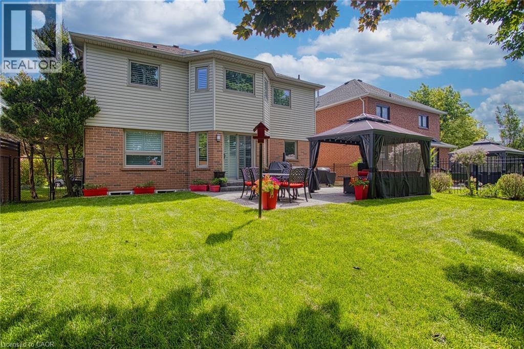 Expansive backyard featuring a large green lawn and a paver patio with a gazebo - 5 Shetland Drive, Waterdown, ON