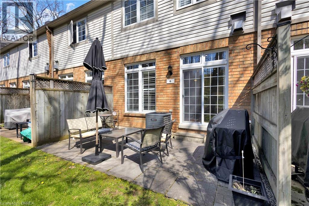Private patio featuring paver stones and a partial wooden fence - 120 Beddoe Drive Unit# 6, Hamilton, ON