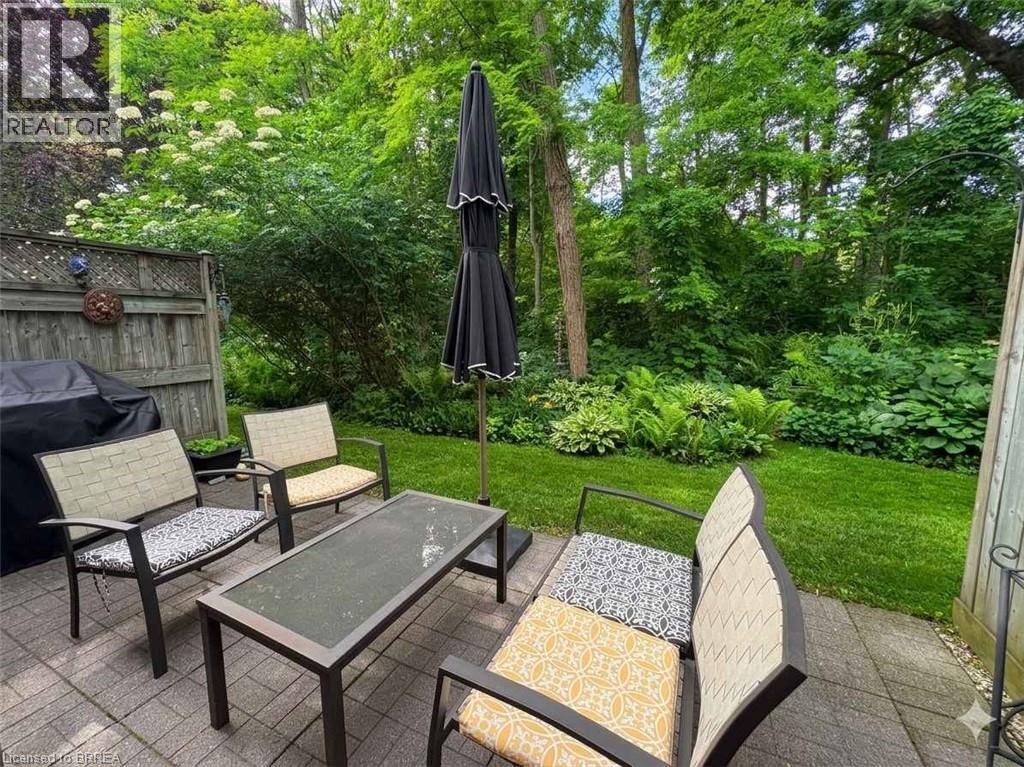 Brick paver patio featuring a privacy fence and a manicured lawn - 120 Beddoe Drive Unit# 6, Hamilton, ON
