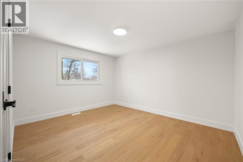 Light wood-finish flooring complemented by white baseboards and walls - 361 Coleridge Place, Waterloo, ON - Indoor Photo Showing Other Room