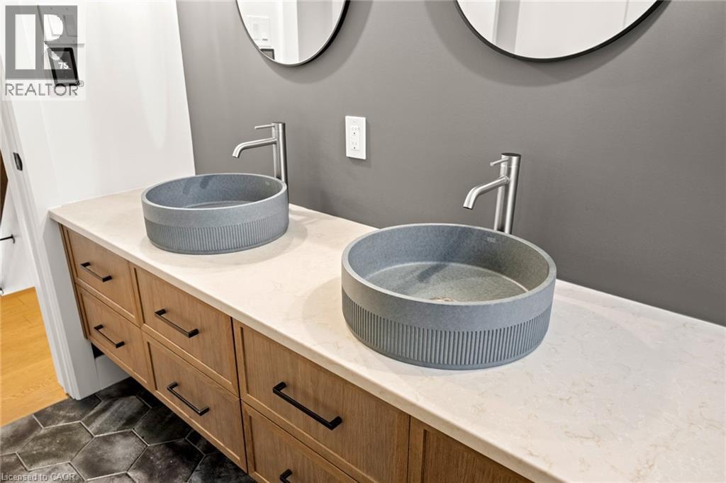 Bathroom vanity featuring dual vessel sinks with modern faucets - 361 Coleridge Place, Waterloo, ON - Indoor