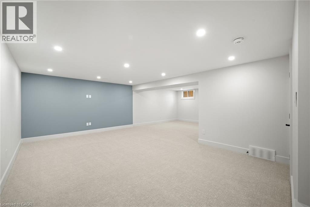 Spacious room featuring light-colored carpeting, recessed lighting, and a prominent accent wall - 361 Coleridge Place, Waterloo, ON - Indoor
