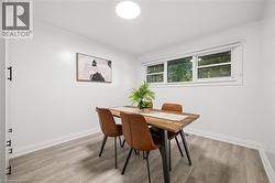 Bright room featuring wood-finish flooring, white walls, and a multi-pane window -