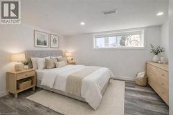 Bedroom featuring wood-finish flooring, a recessed window, and white walls -