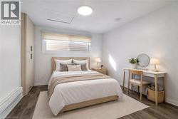 Bright interior space featuring wood-finish flooring, a built-in wardrobe with contemporary hardware, and a window with blinds -