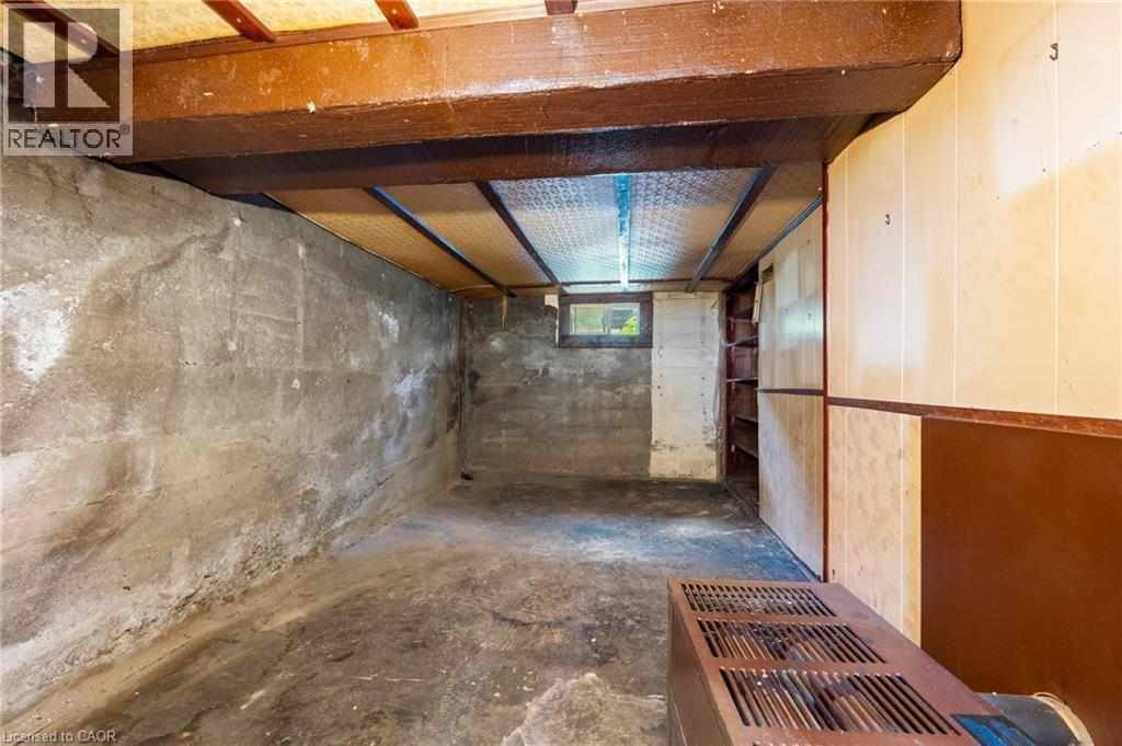 Unfinished lower level with exposed ceiling beams and concrete walls - 35 Basil Avenue, Simcoe, ON